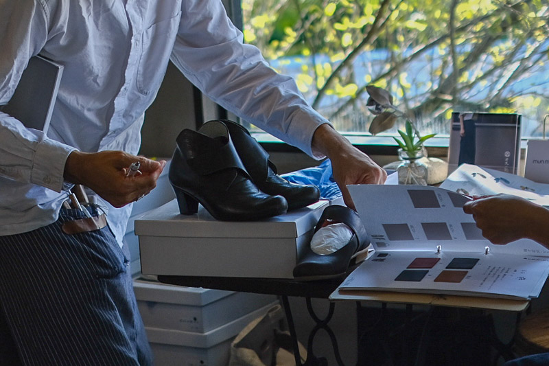 革見本帳を広げ、靴のデザインと革素材を選んでいる様子